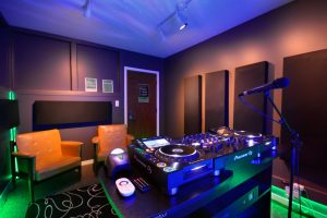 DJ Studio featuring Pioneer CDJs, color changing lights, automated recording, live-streaming capabilities, and microphones.